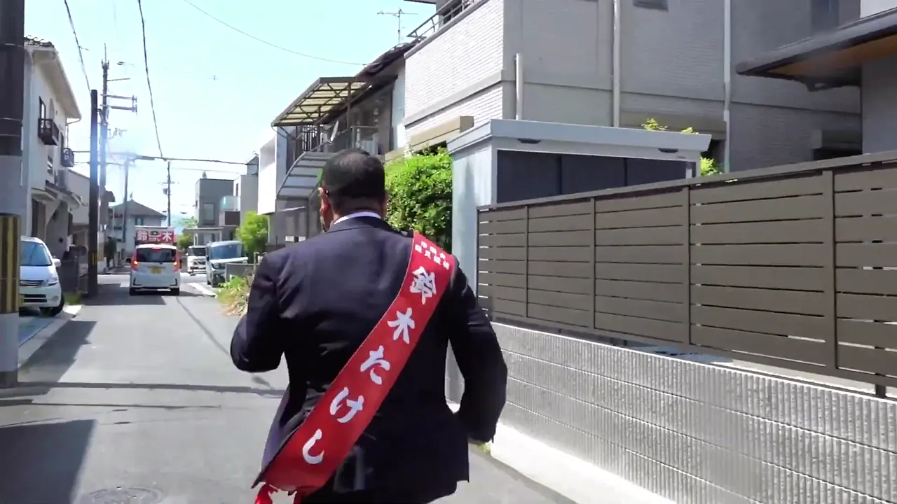 住宅街を歩く鈴木たけしの後ろ姿